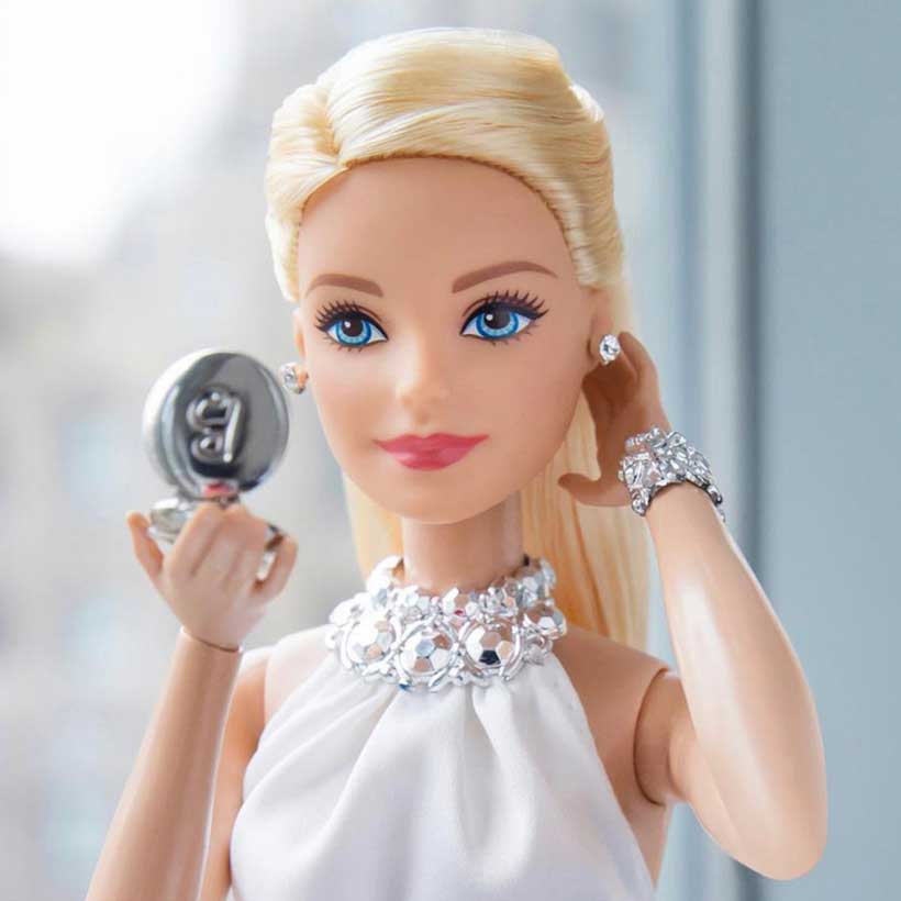 Poupée Barbie se regardant dans un miroir de poche
